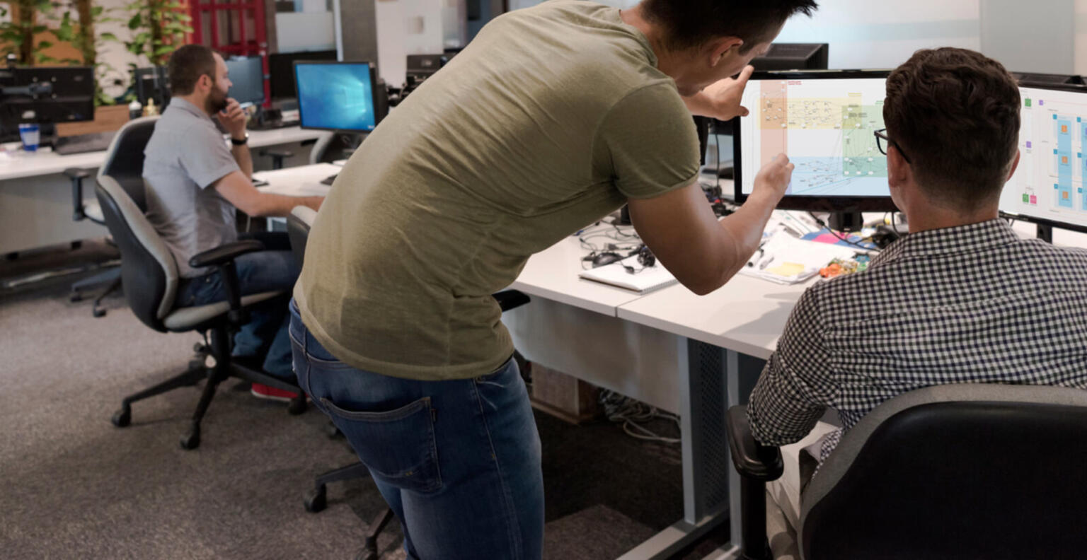 two people collaborating at desktop computer screens.