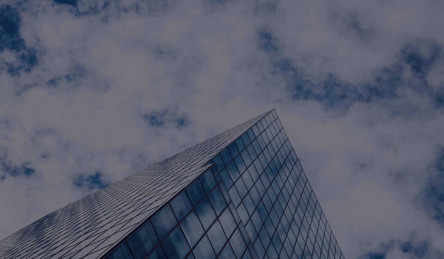 White cloud passing over modern glass technology center building.