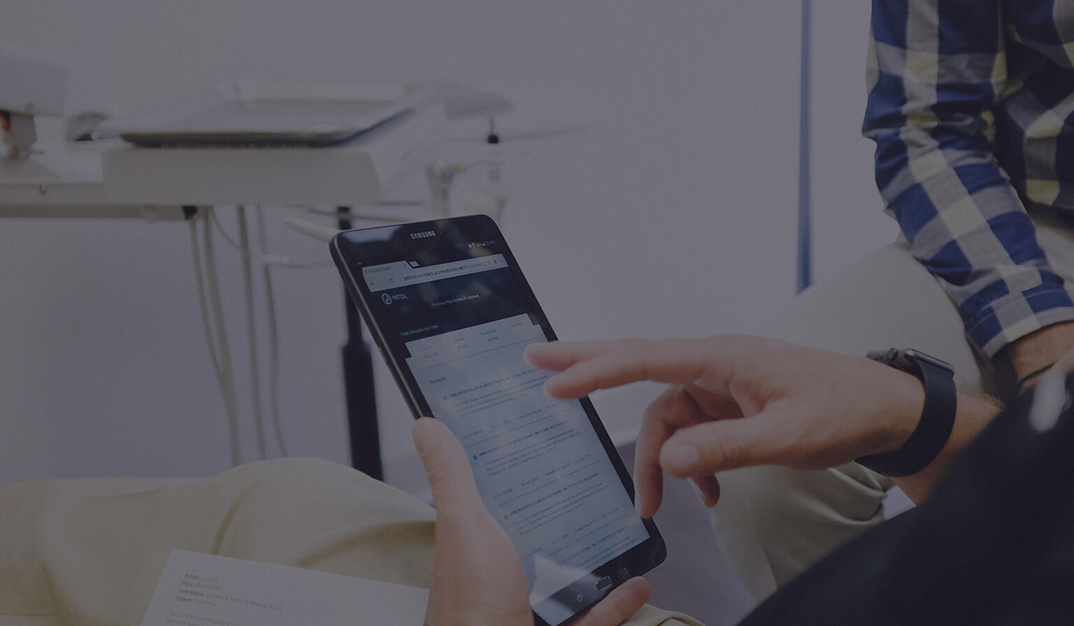 Dental patient tapping on a handheld tablet.
