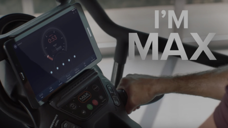 Still from a Nautilus video featuring exercise equipment and display tablet.
